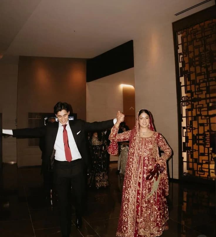 The groom walking the bride in, arms wide